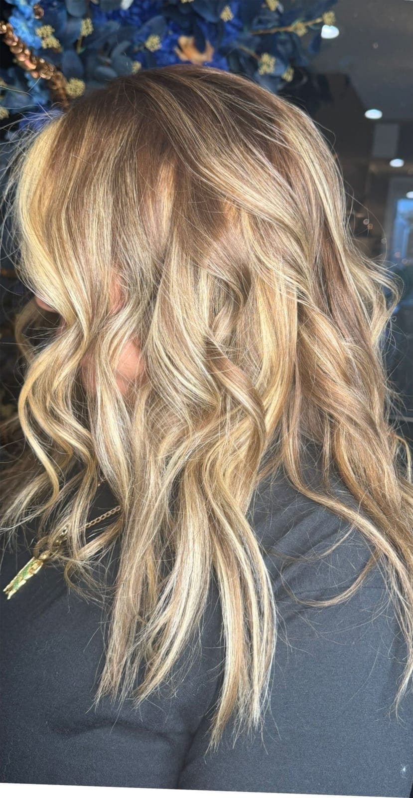 Even, multi-tonal blonde waves falling over a dark top
