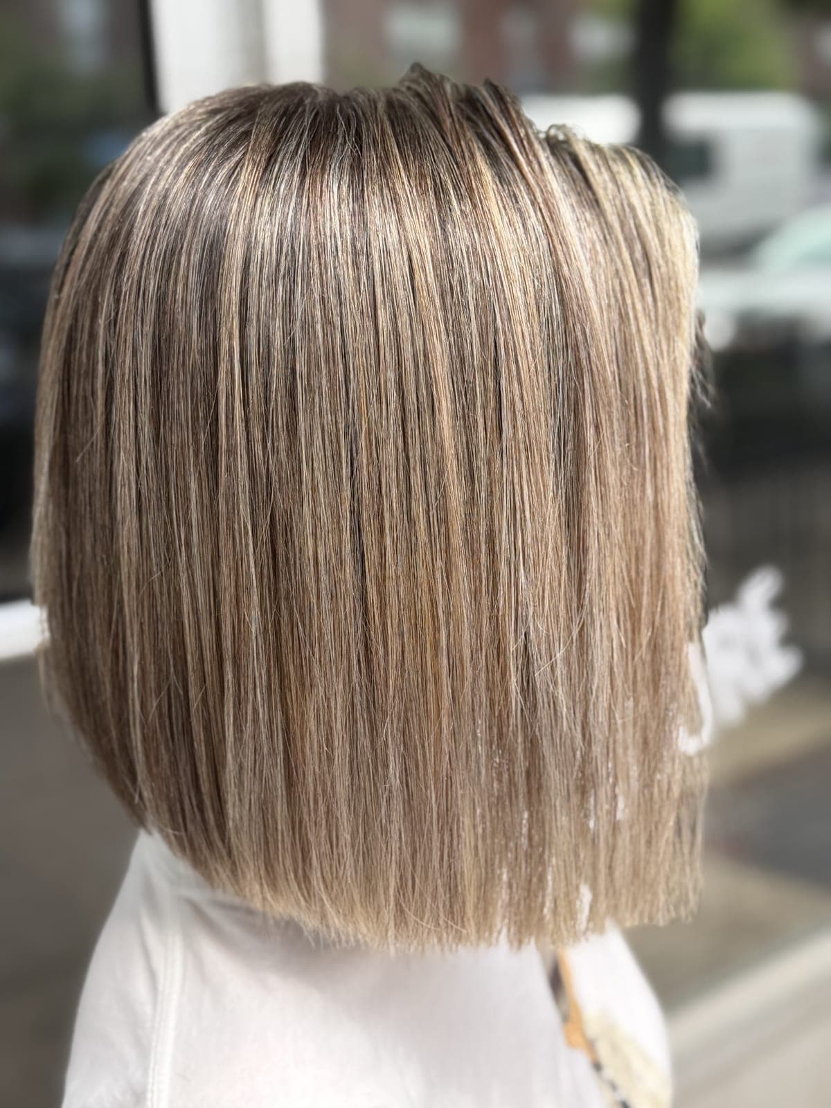 Straight ash-blonde hair with fine, even highlights, photographed from the back